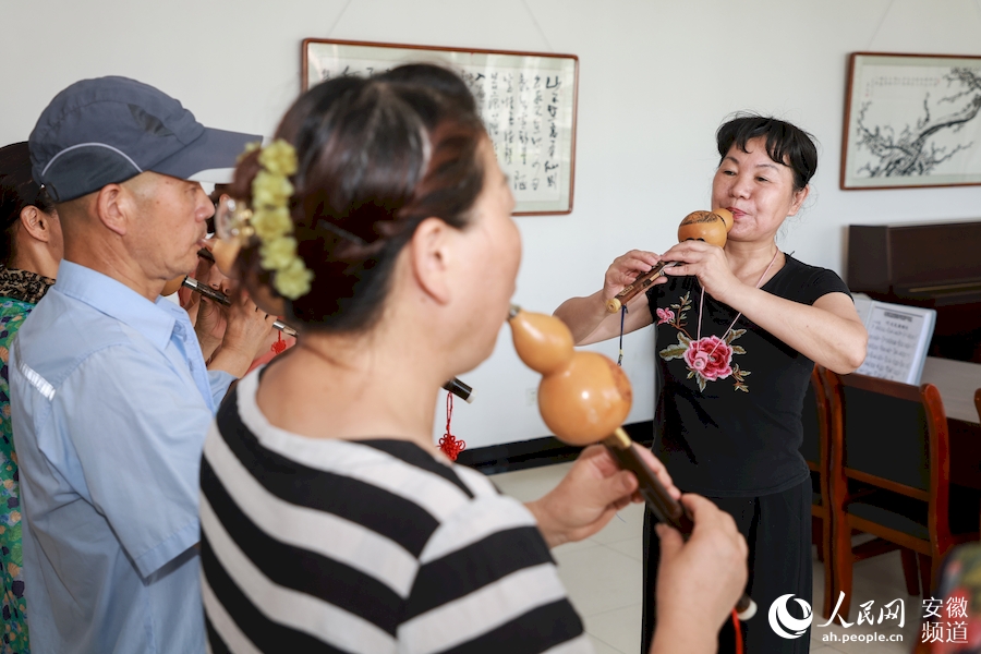 在老师的带领下，学员们吹着葫芦丝。人民网 张俊摄